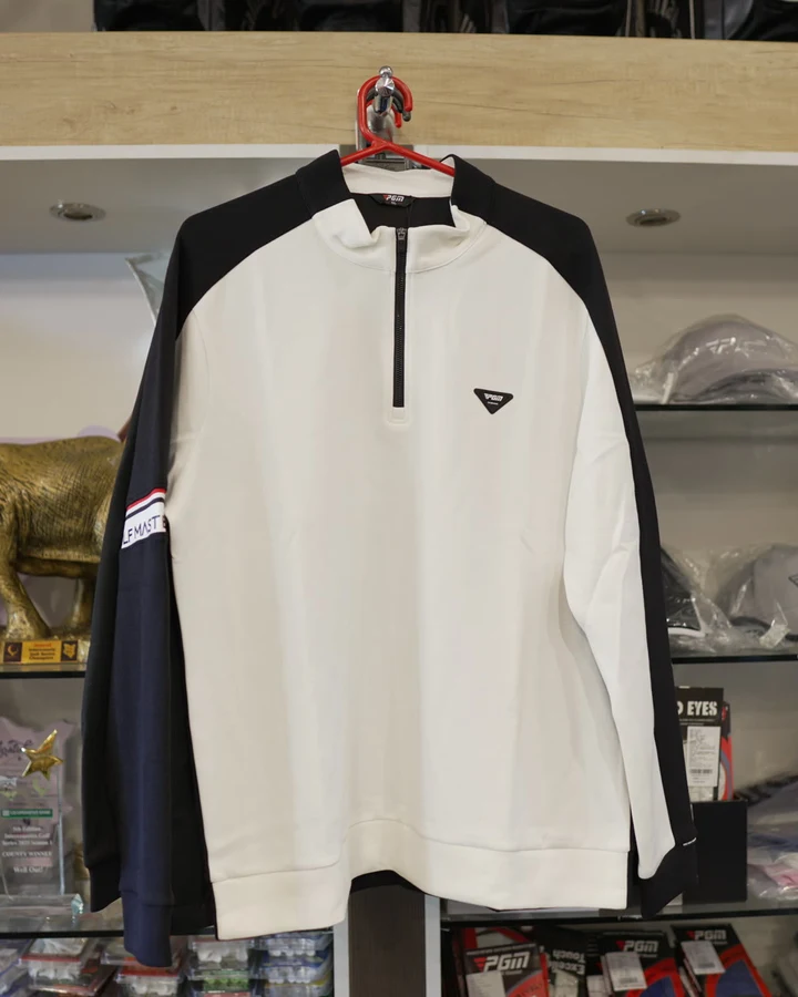 A white and black Callaway quarter-zip midlayer on a hanger in the shop