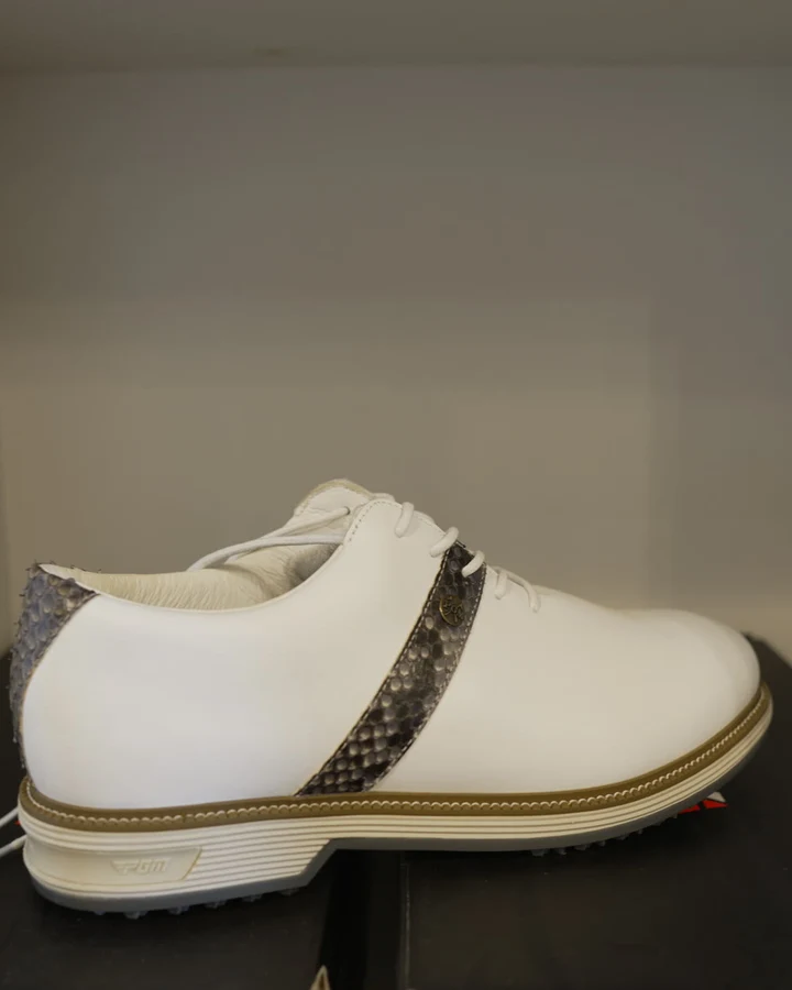 Two women's golf shoes in white and cream displayed on red shoe boxes