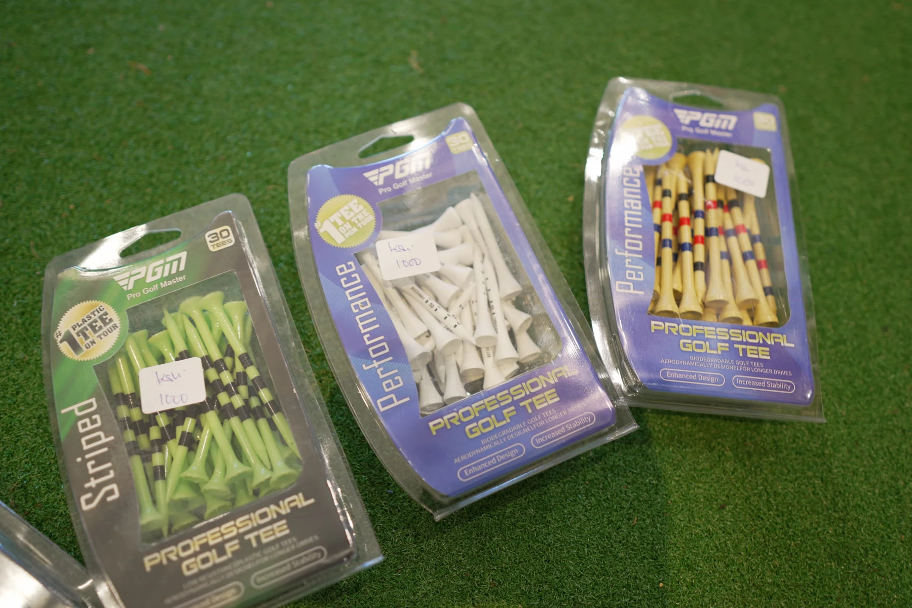 Packs of coloured wooden golf tees displayed on the shop's putting turf