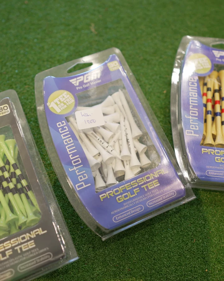 Packs of coloured wooden golf tees displayed on the shop's putting turf